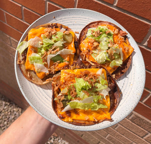 A plate of three big mac tacos in the sun in front of a brick wall