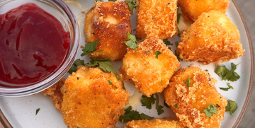 brie bites on a plate with Spiced Cranberry Ketchup on the side