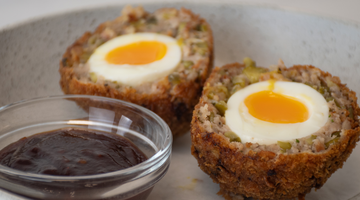 large scotch eggs on a plate with Scotch Bonnet Chilli Jam in the foreground