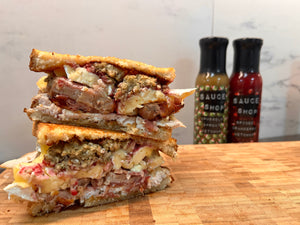A photo of the christmas toastie, stacked on top of each other and Brussels Sprout Ketchup and Spiced Cranberry Ketchup in the background
