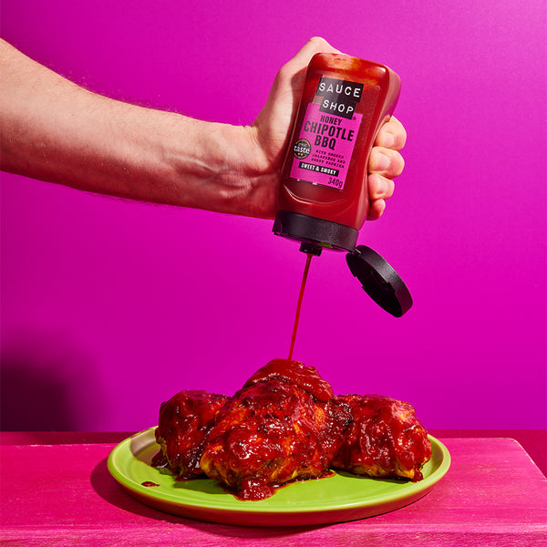  Sauce Shop Honey Chipotle BBQ Sauce Being Squeezed over Chicken Thighs on a Green Plate  